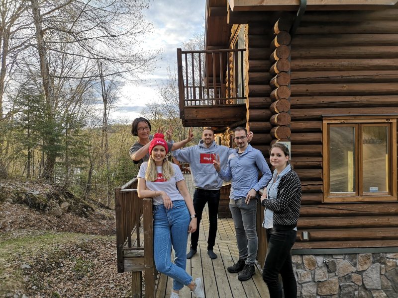 L'équipe Maplr devant un chalet en bois rond dans les Laurentides